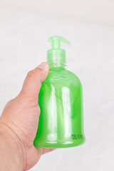Bottle of liquid soap in the bottle in the hand above white background