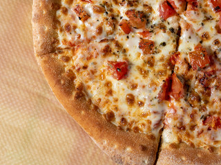 pizza Margarita close-up on parchment. Italian dish with tomatoes cheese and herbs