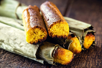 Broa made with corn and wrapped in banana leaf. Rural Brazilian dessert made in the states of São Paulo and Minas Gerais, known as Brazilian bread-a-pique, bread or Brazilian corn bread.