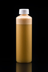 fresh brown smoothie in a bottle on a black background