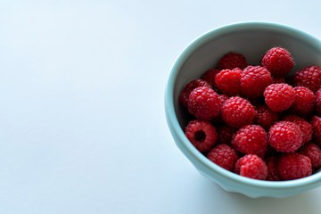 Fresh raspberries in a blue bowl