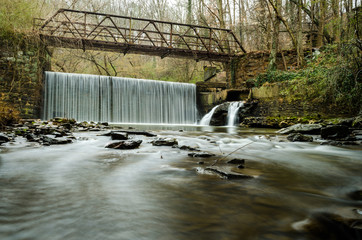 Scenic dam waterfall, bridge,  and creek at Hahn Woods at Emory University