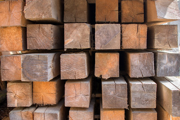 the square bar intended for construction is carefully laid in rows. Close-up photo, cropped