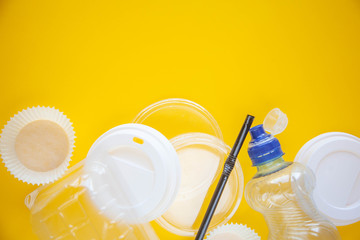 Human household waste on a yellow background. Say no to the plastic. The concept of recycling and ecology. Copy space for text.
