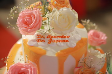 Indian reception wedding cake with roses and donuts