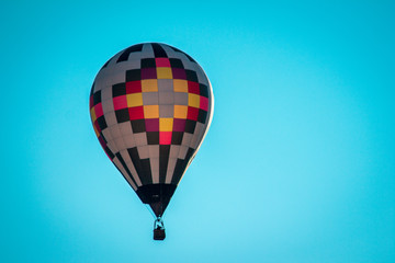 Naklejka premium Hot air balloon flying by in a clear blue sky during an airshow on a summer night in Michigan