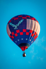 Hot air balloon flying by in a clear blue sky during an airshow