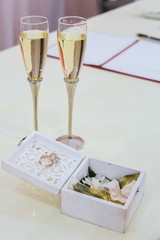 wedding rings in a decorative box, two glasses of champagne
