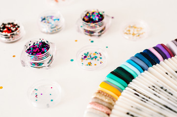 Nail designs on tips and manicure set on a colored background.