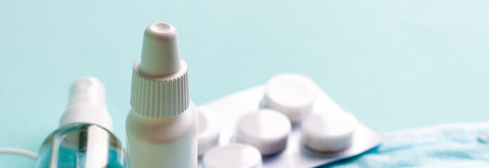 Fototapeta premium Pills, tablets and bottle on turquoise background. Copy space