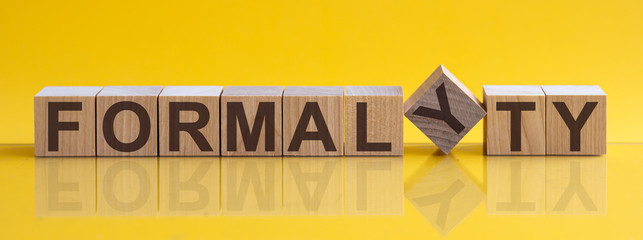 FORMALYTY - word from wooden blocks with letters, sorry concept, yellow background.