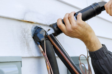 Sealing silicone holes after installation of air conditioning pipes technological for a new house