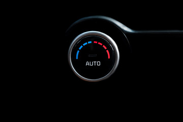 Car air button on a black background, with indicator.
