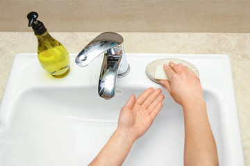 A Hands with soap are washed under the tap with water. Clean from infection and dirt and virus. At...