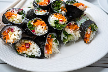 Vietnamese vegan rice paper and nori sheet spring rolls on white plate