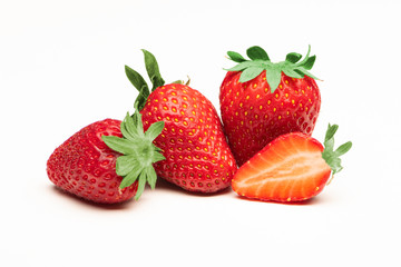 fresh strawberries and a sliced strawberry close up on a white background