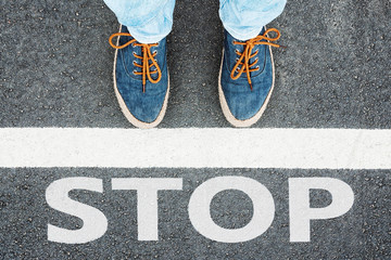 Women's feet in sneakers stand at the line with the inscription 