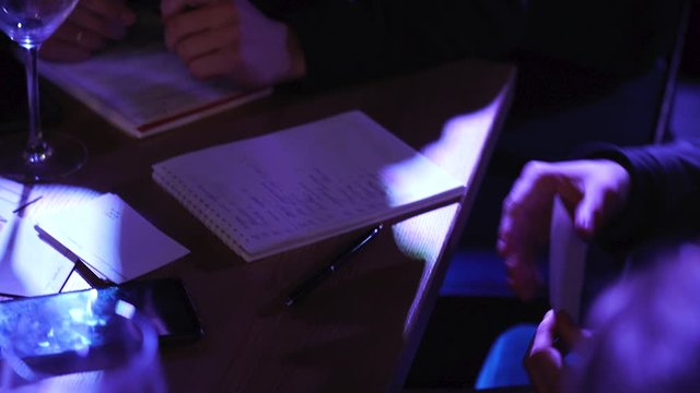 Cloes up. The male hand makes an entry in the notebook. The hand that records. Writing to notebook