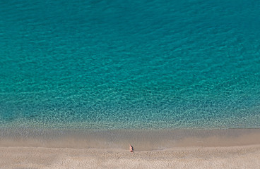 Girl on the beach in summer near clear blue sea. Copy space. Top view