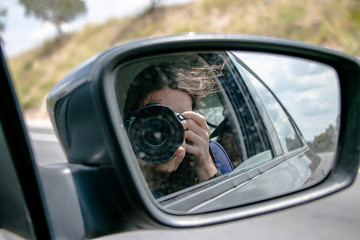 Chica tomando foto viajando en carro