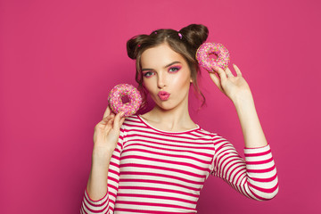 Pretty girl with donuts on vivid pink background