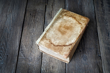 Aged book with empty cover on a wooden background. Copy space.