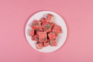 sweet dessert on a plate on a rose background, a view from above