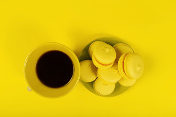 coffee and yellow biscuits on a yellow background, a view from above