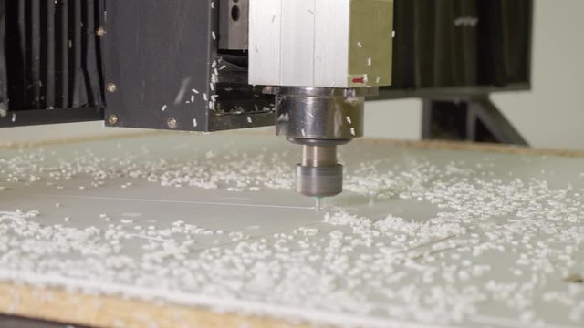 Milling machine cut the shape out of plastic canvas. A lot of flakes. Close up