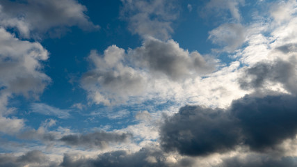 A cluster of light and fluffy clouds interspersed with dark gray clouds. Before the rain and the thunderstorm.