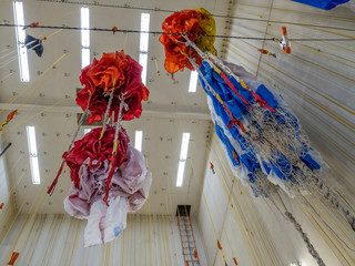 Parachutes hanging from ceiling after being checked and waiting for folding and packing prior to...