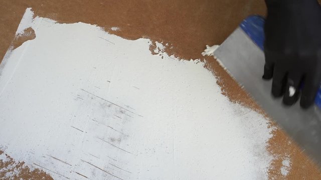 applying gypsum putty to the surface with a spatula. the process of creating a design background for your photos