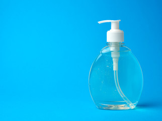 transparent plastic bottle with a sanitizer for disinfecting hands on a blue background