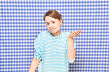 Portrait of disappointed girl with white spots of cosmetic on face