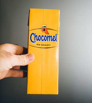 Paris, France - Dec 27, 2019: man hand holding yellow pack of Chocomel chocolate drink against gray background
