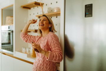 Portrait of beautiful young woman enjoying favorite music from smartphone. Young woman enjoying her...