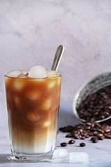 Iced coffee drink in a glass on the light background