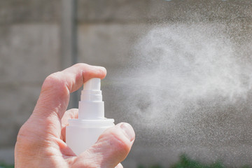 A man sprays antiseptic from a can