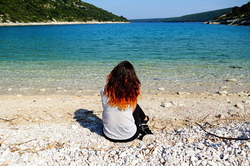 Beautiful nature in a turquoise-blue lagoon and a young woman enjoying the sea