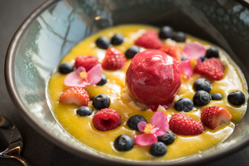 Berry sorbet with yellow mango sauce, and berries