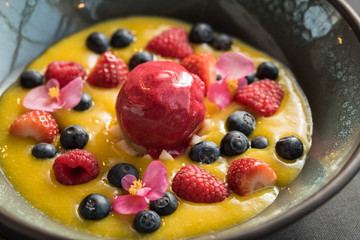 Berry sorbet with yellow mango sauce, and berries