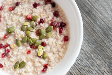 Oatmeal with almonds and berries, in a white plate top view.
