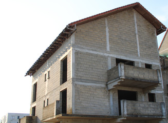 Floor building under construction. View of walls of cinder block. Foundation with reinforcement scrap. Window insert not installed yet. Site of an industrial contractor.