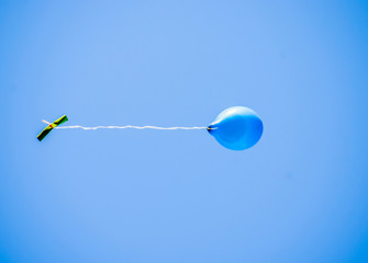 colorful balloons flying in the blue sky with message written by children