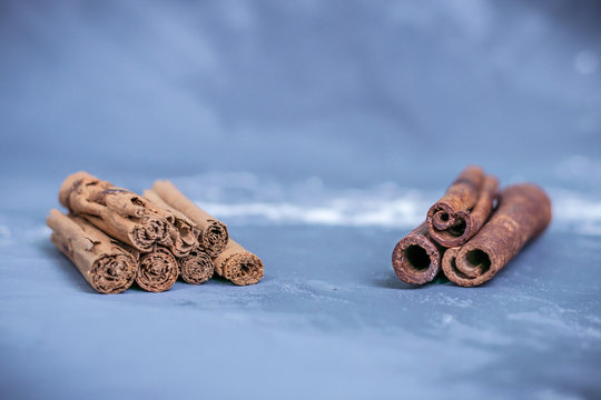 Chinese cassia originated from China and ceylon cinnamon verum from Sri Lanka bark sticks on a gray-blue background sprinkled with flour the difference between real and fake