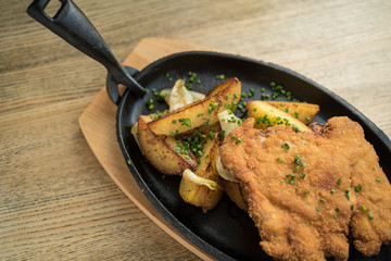 Breaded pork meat with fried potatoes
