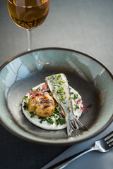Cooked white fish with baked potato, spring onions