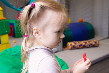 little girl having fun with colorful modeling clay, dough or plasticine