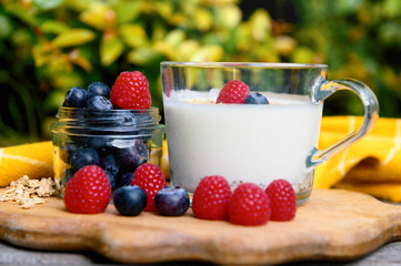 Eating a healthy breakfast. Yogurt, granola, chia seeds, fresh and dry fruits, blueberries, raspberries in a transparent. Clean food, diet, detox, vegetarian food concept.