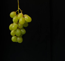 a lonely bunch of grapes on black background